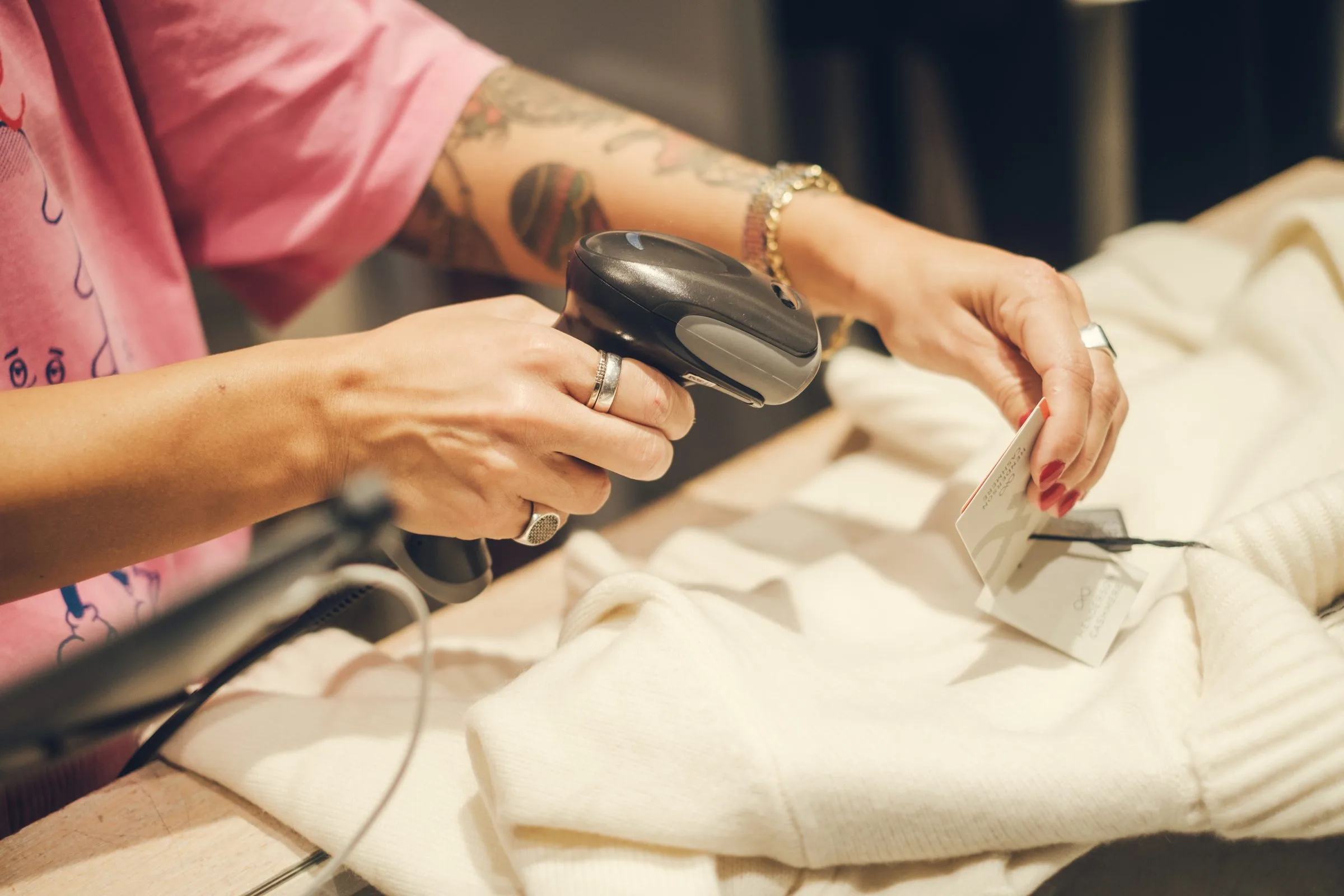 A store assistant scanning a price tag at the counter